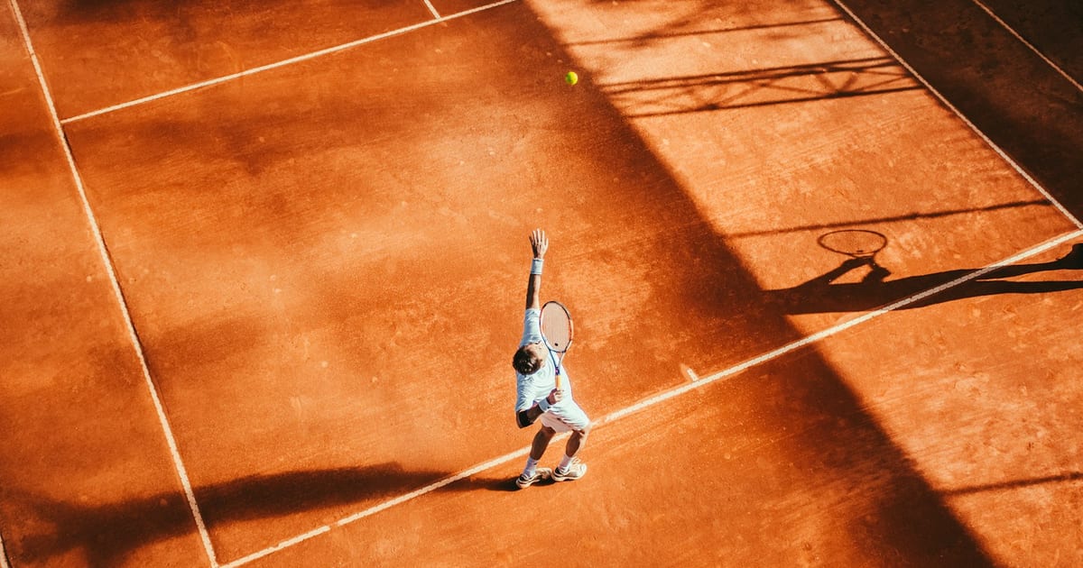 Un tennista in azione su un campo in erba
